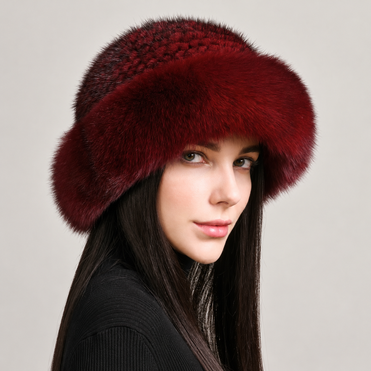 Burgundy knitted mink hat with a wide fox fur brim, shown from the side on a model.