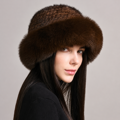 Dark brown knitted mink hat with a wide fox fur brim, shown from the side on a model.