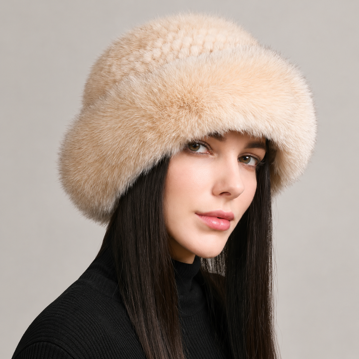 Cream beige knitted mink hat with a fluffy fox fur brim, shown from the side on a model.