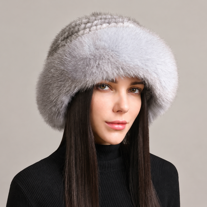 Silver gray knitted mink hat with a fluffy fox fur brim, shown from the front on a model.