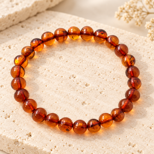 Polished cognac Baltic amber stretch bracelet on beige stone