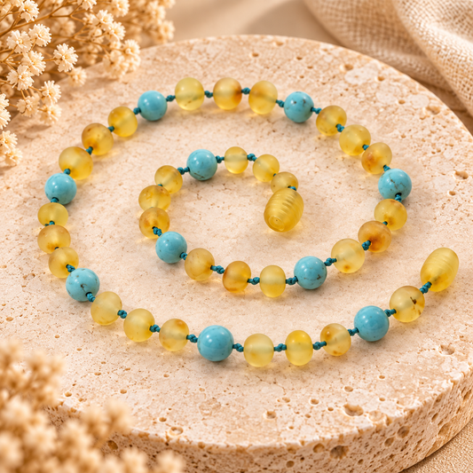 Baltic amber and turquoise necklace on warm beige stone