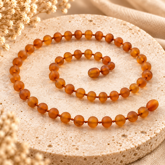 Raw cognac Baltic amber necklace on warm beige stone